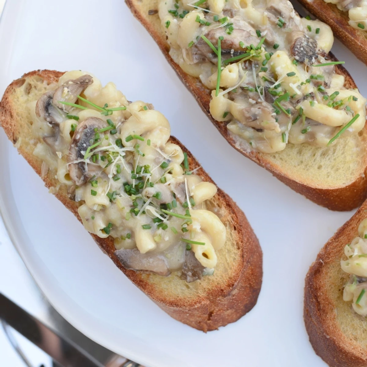 Deliciously creamy truffled mushroom mac crostini served warm for gourmet snacking.