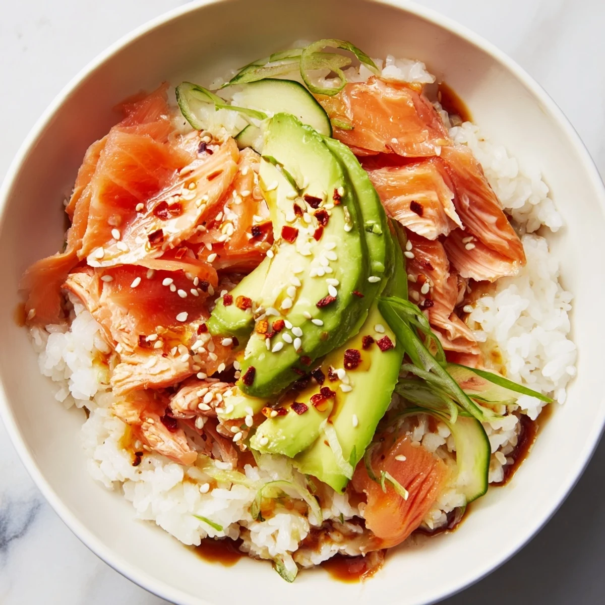 Delicious leftover salmon and rice bowl topped with vibrant veggies and sauces.  