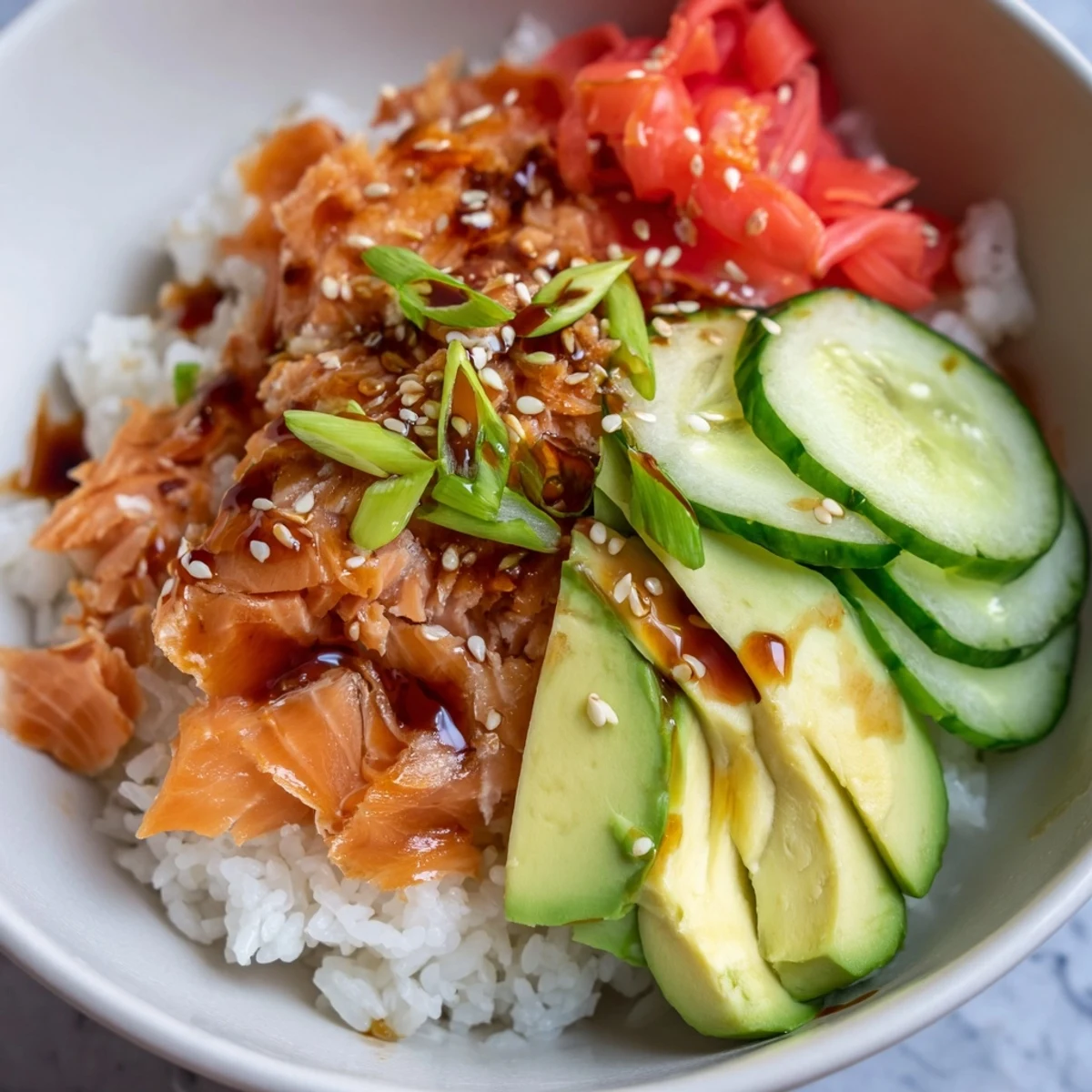 Flavorful leftover salmon and rice bowl, finished with sesame seeds and scallions.
