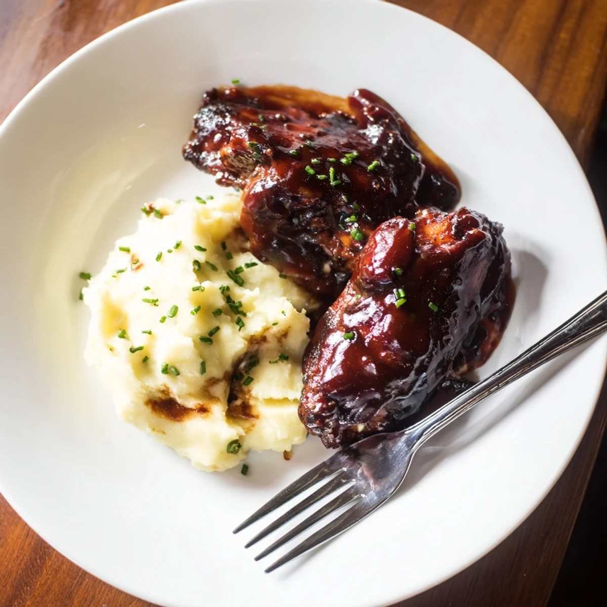Juicy honey BBQ chicken thighs glistening with sauce, paired with creamy garlic mashed potatoes.  