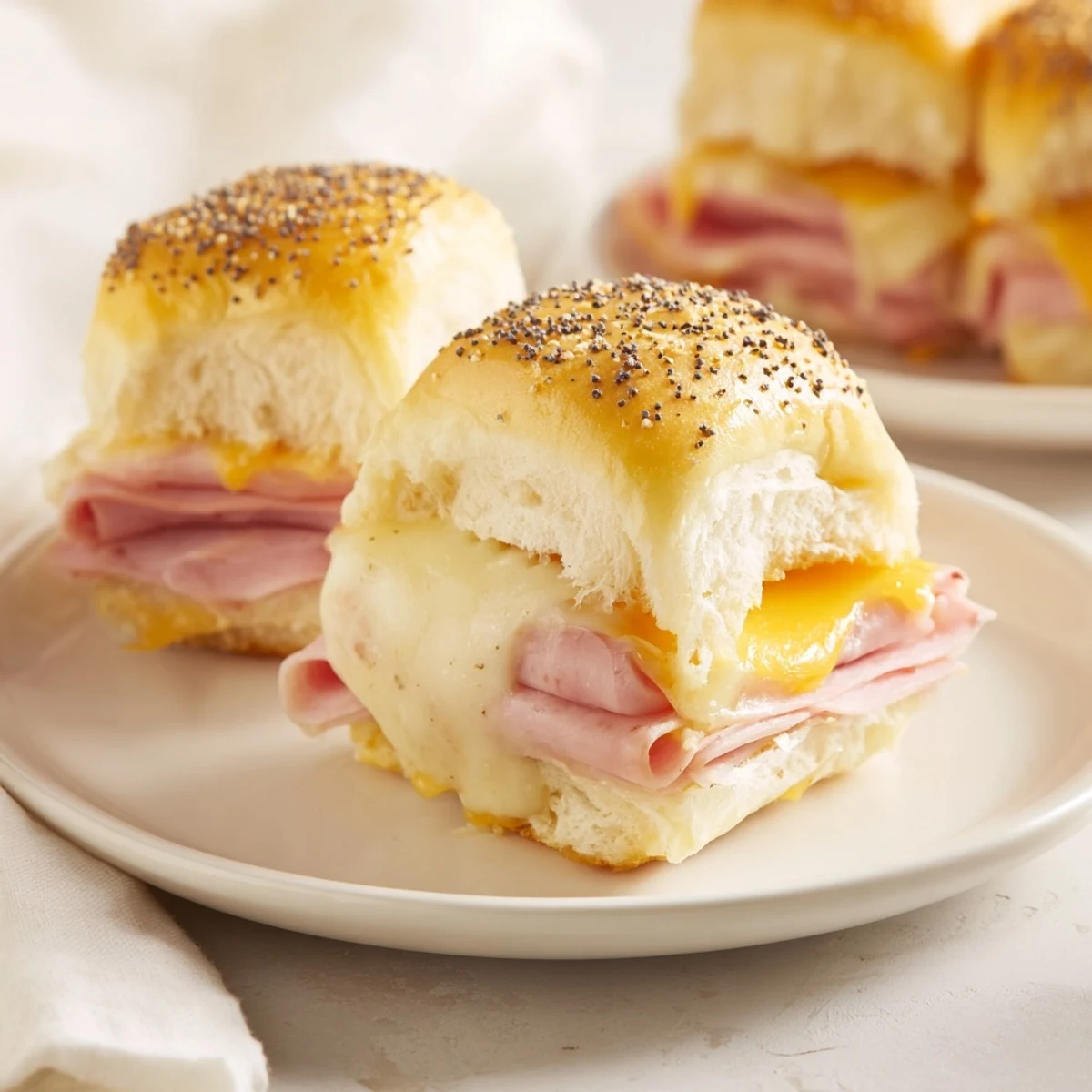 Mouthwatering, golden-brown Baked Ham and Cheese Party Sliders layered with ham and melted cheese.
