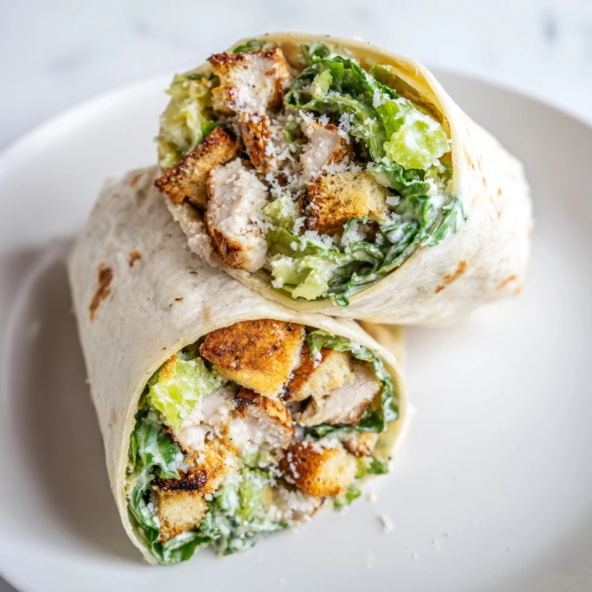 Golden-brown Chicken Caesar Wraps, showing a cross-section revealing the fresh, crunchy ingredients inside.
