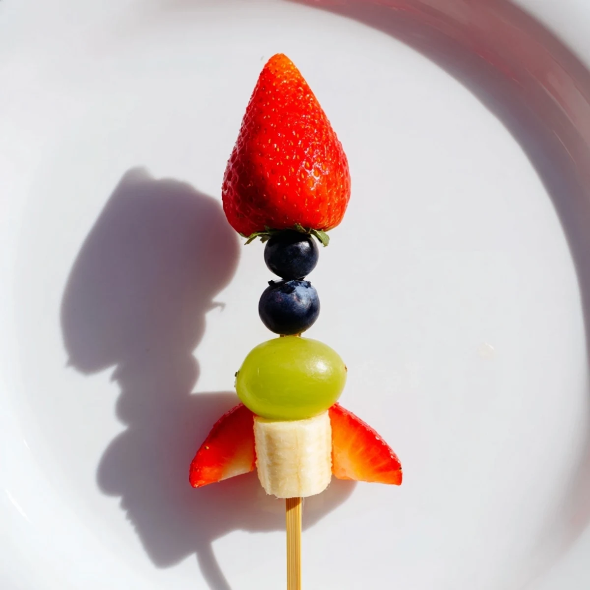 Fresh Rocket Ship Fruit Skewers featuring pineapple flames, green grapes, and a strawberry tip.