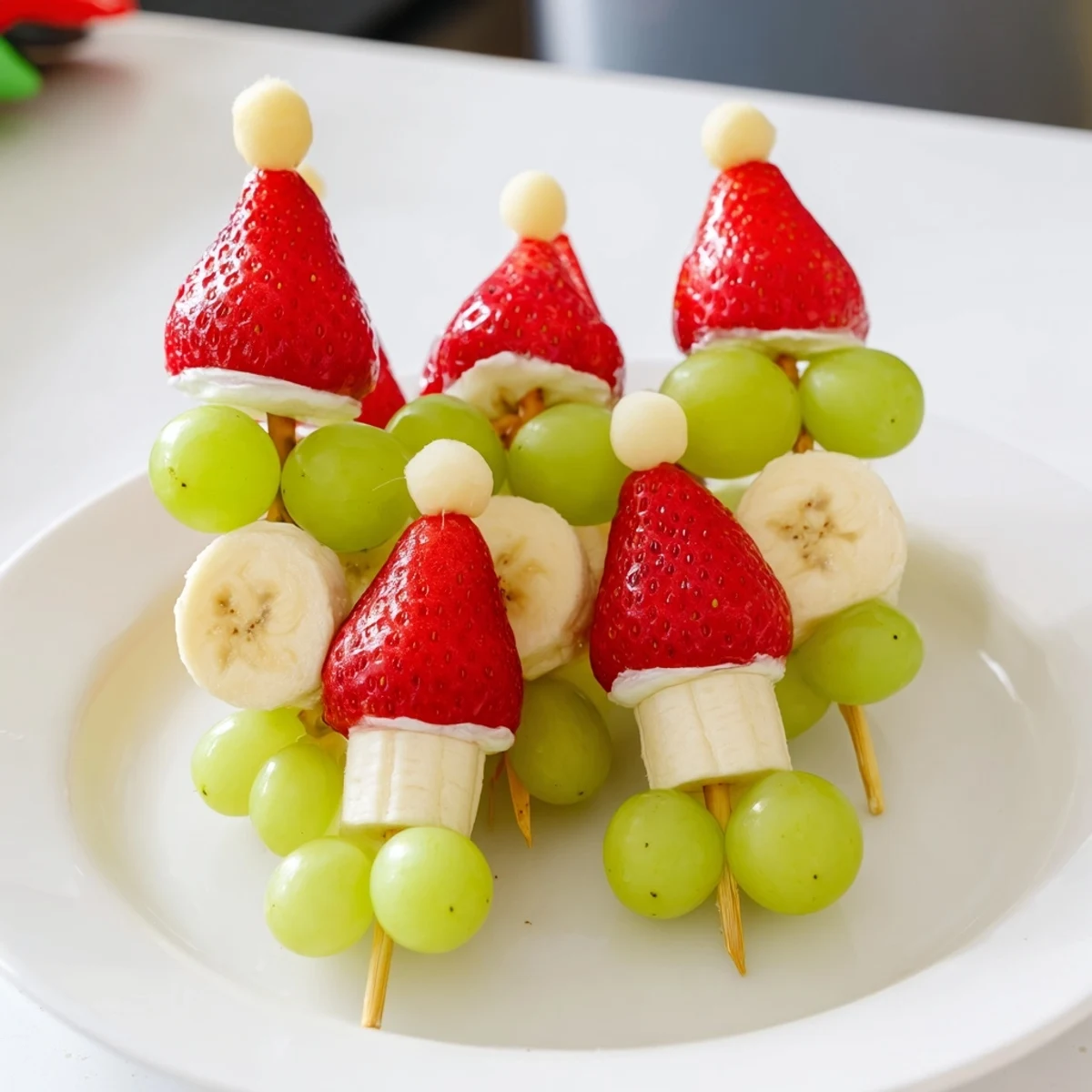 Get the flavor with Elf Hat Strawberry Skewers; a colorful snack of fresh fruit perfect for kids' parties.