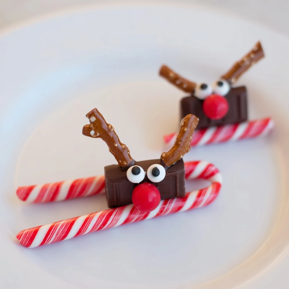 Sweet, no-bake Rudolph Candy Cane Sleds display colorful candy faces; a fun, easy treat idea for everyone.