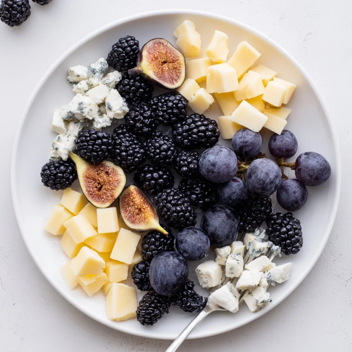 A beautiful Deep Indigo Midnight Sky cheese board, showcasing blackberries, figs, and creamy goat cheese.