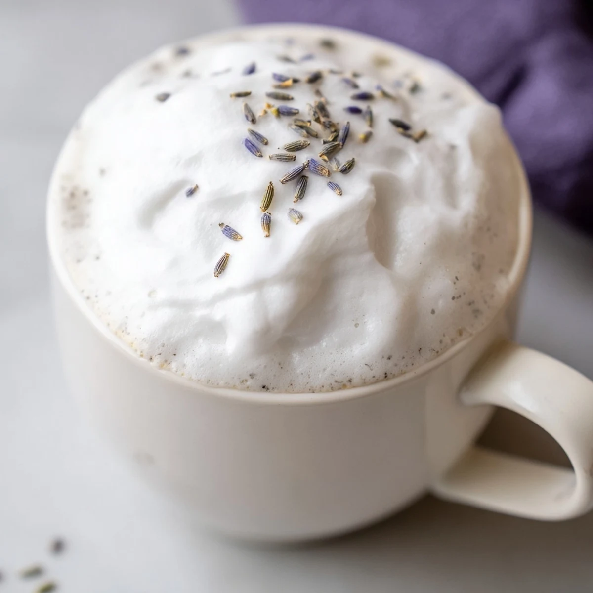 Close-up of a frothy Whipped Lavender Latte with hints of purple, a delightful homemade beverage.