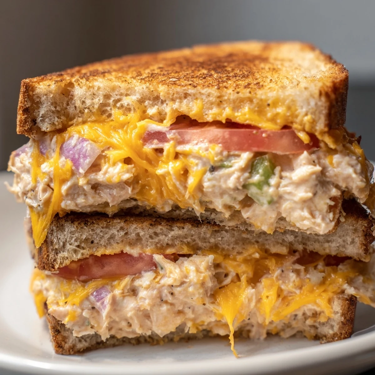 A skillet-cooked spicy tuna melt featuring zesty tuna salad and melted cheddar, ready to serve.