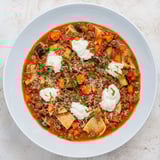 A close-up of a hearty bowl of Healthy Lasagna Soup, garnished with fresh herbs and cheese.