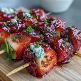 Festive Fourth of July fruit skewers with strawberries, bananas, and blueberries arranged in patriotic colors.