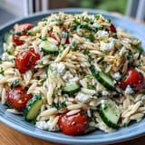 Creamy feta and crisp cucumber mingle with tender orzo pasta in this bright, lemon-dressed salad, ideal for summer gatherings.  