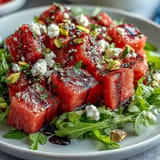 Vibrant watermelon feta arugula salad with balsamic reduction ready to serve.