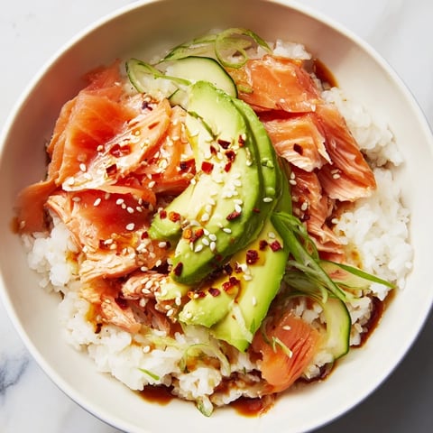 Delicious leftover salmon and rice bowl topped with vibrant veggies and sauces.  