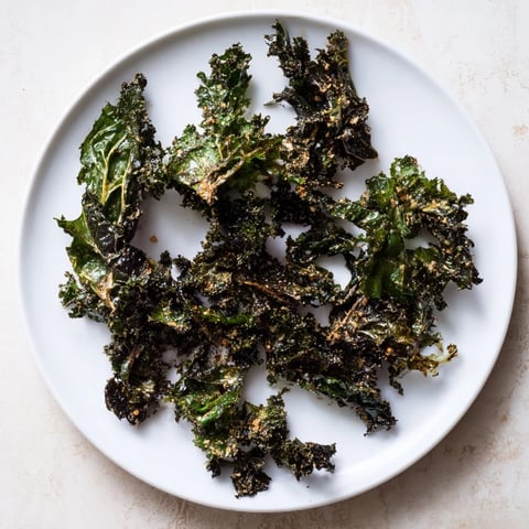 Golden, crunchy baked kale chips, a healthy snack, ready for a satisfying, salty bite.