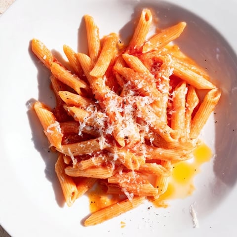 Steaming Microwave Bowl Pasta, ready in minutes, with optional Parmesan cheese sprinkled on top.
