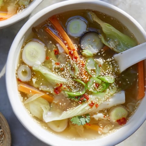 Steaming bowls of Ginger-Miso Winter Soup are garnished with toasted sesame seeds and fresh cilantro.  