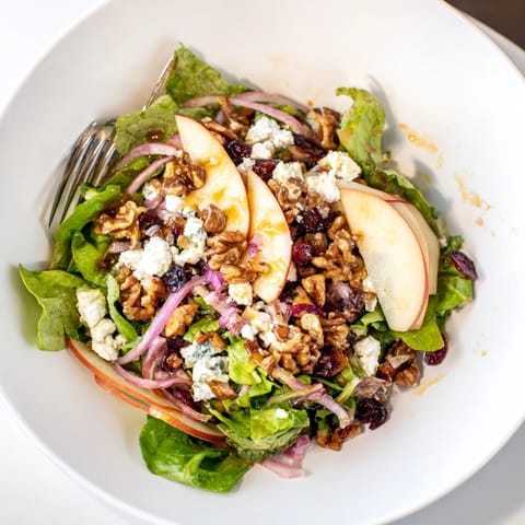 Crisp Autumn Harvest Apple Feta Salad, drizzled with maple vinaigrette, ready to serve.