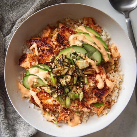 Vibrant bowl of Crispy Salmon Rice Bowl topped with golden garlic and sesame seeds.  