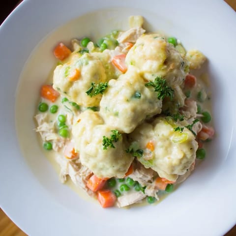 A close-up of a warm, comforting Chicken and Dumplings Casserole with visible diced vegetables.