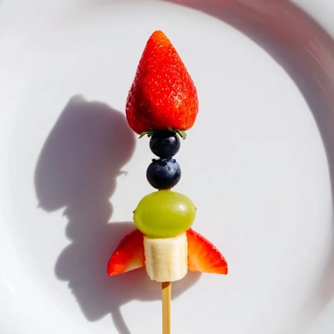 Fresh Rocket Ship Fruit Skewers featuring pineapple flames, green grapes, and a strawberry tip.