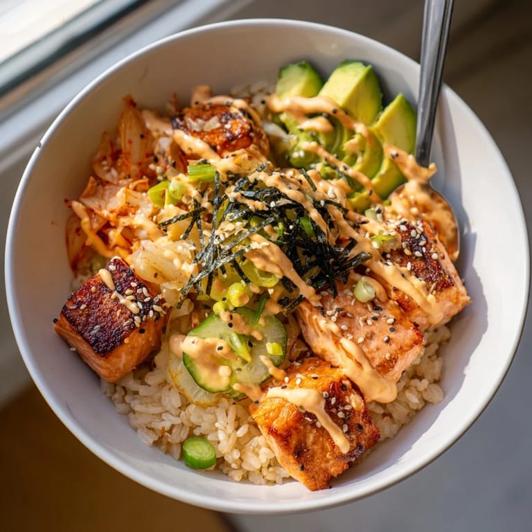 Delicious Crispy Salmon Rice Bowl featuring fluffy rice, spicy mayo, and tangy toppings.