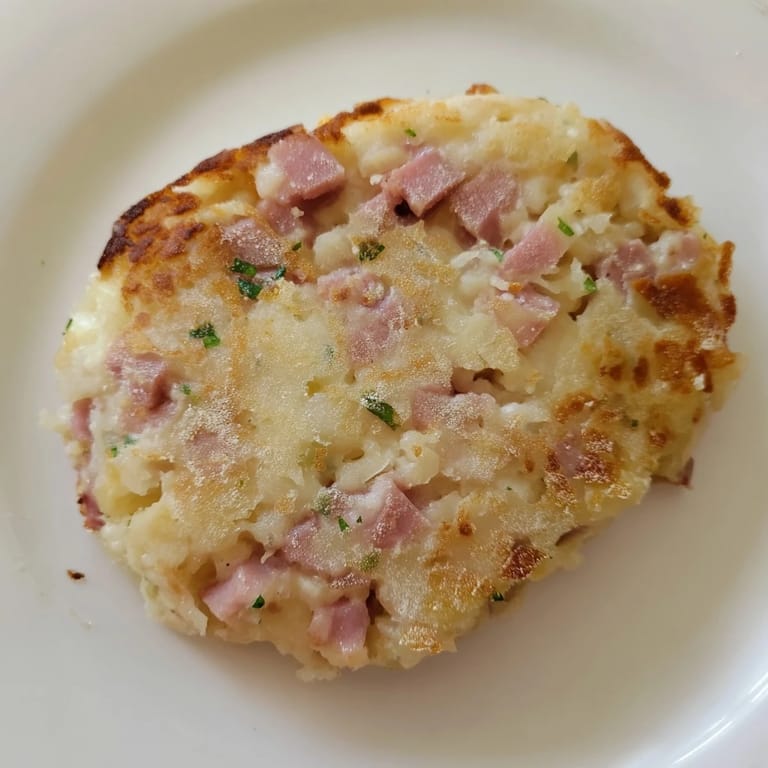 A stack of savory Depression-Era Ham & Potato Patties, with visible bits of ham and onion.