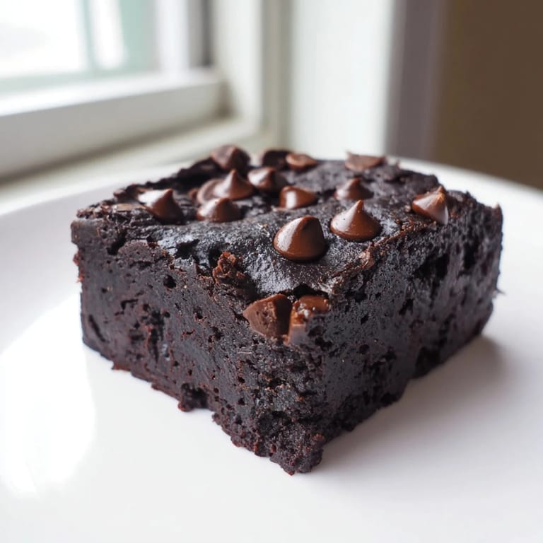 A close-up of a square of Black Bean Brownies, rich and moist, a perfect gluten-free dessert option.