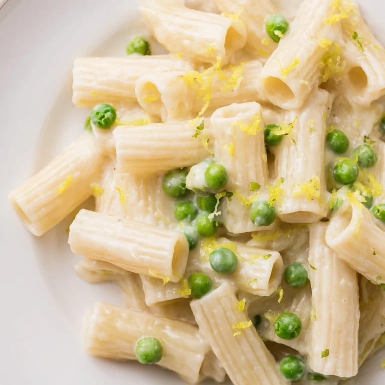 A close-up of warm Pea & Lemon Ricotta Pasta with sweet green peas and a silky ricotta-lemon sauce, ready for an easy spring dinner.  