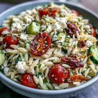 A vibrant Mediterranean orzo salad with cucumber, feta, and zesty lemon dressing, perfect for a refreshing lunch or side dish.  